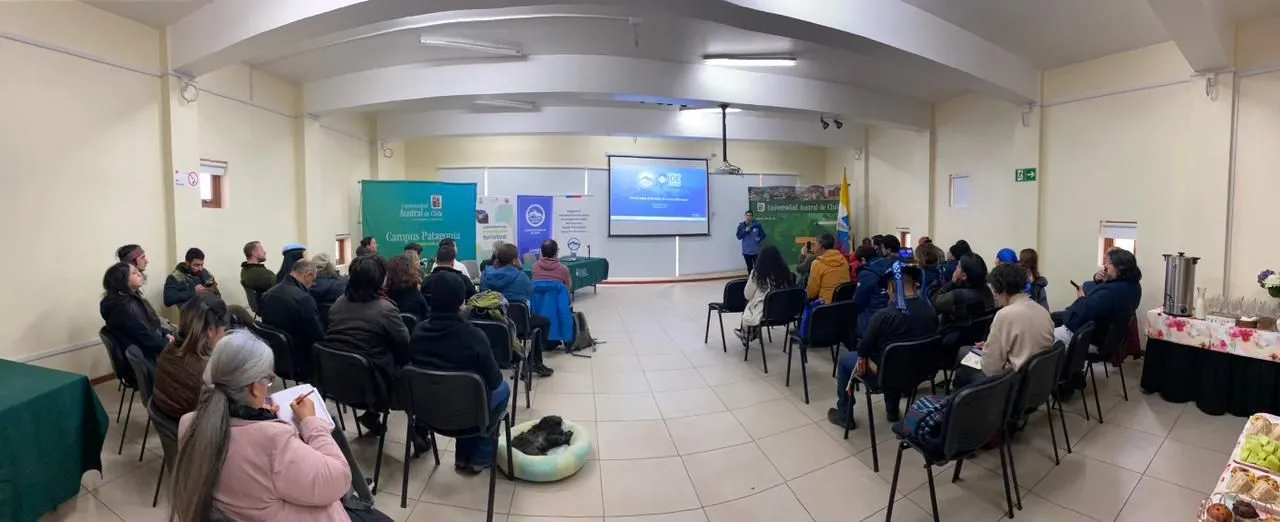 Vista panorámica del auditorio del Campus Patagonia, con una treintena de asistentes sentados frente al expositor y a la pantalla de la presentación.