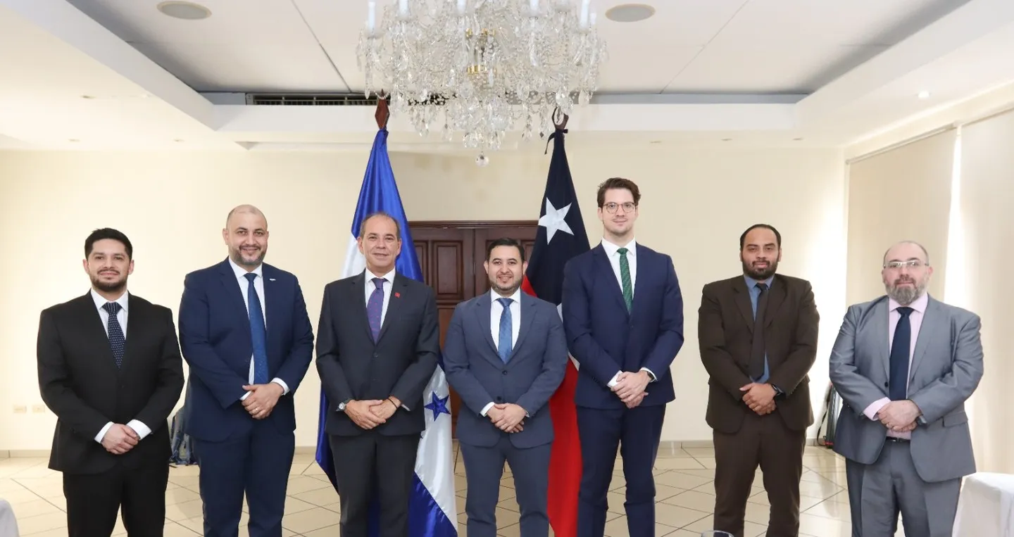 Fotografía oficial de la jornada de cierre: siete representantes de Honduras y de Chile, de pie entre las banderas de ambos países.