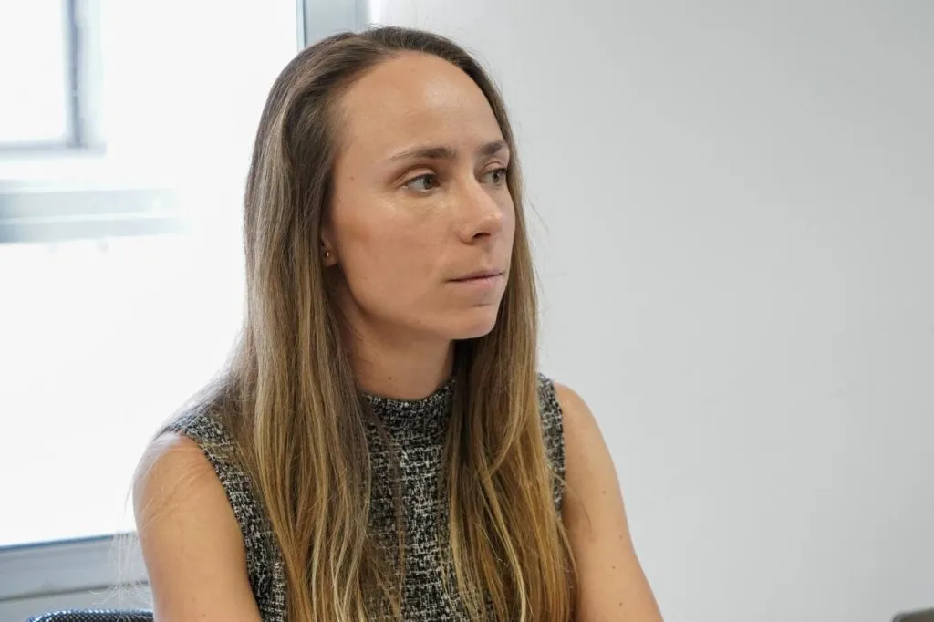 Retrato de la Secretaria Ejecutiva del SNIT sentada junto a una ventana, atenta a la conversación.