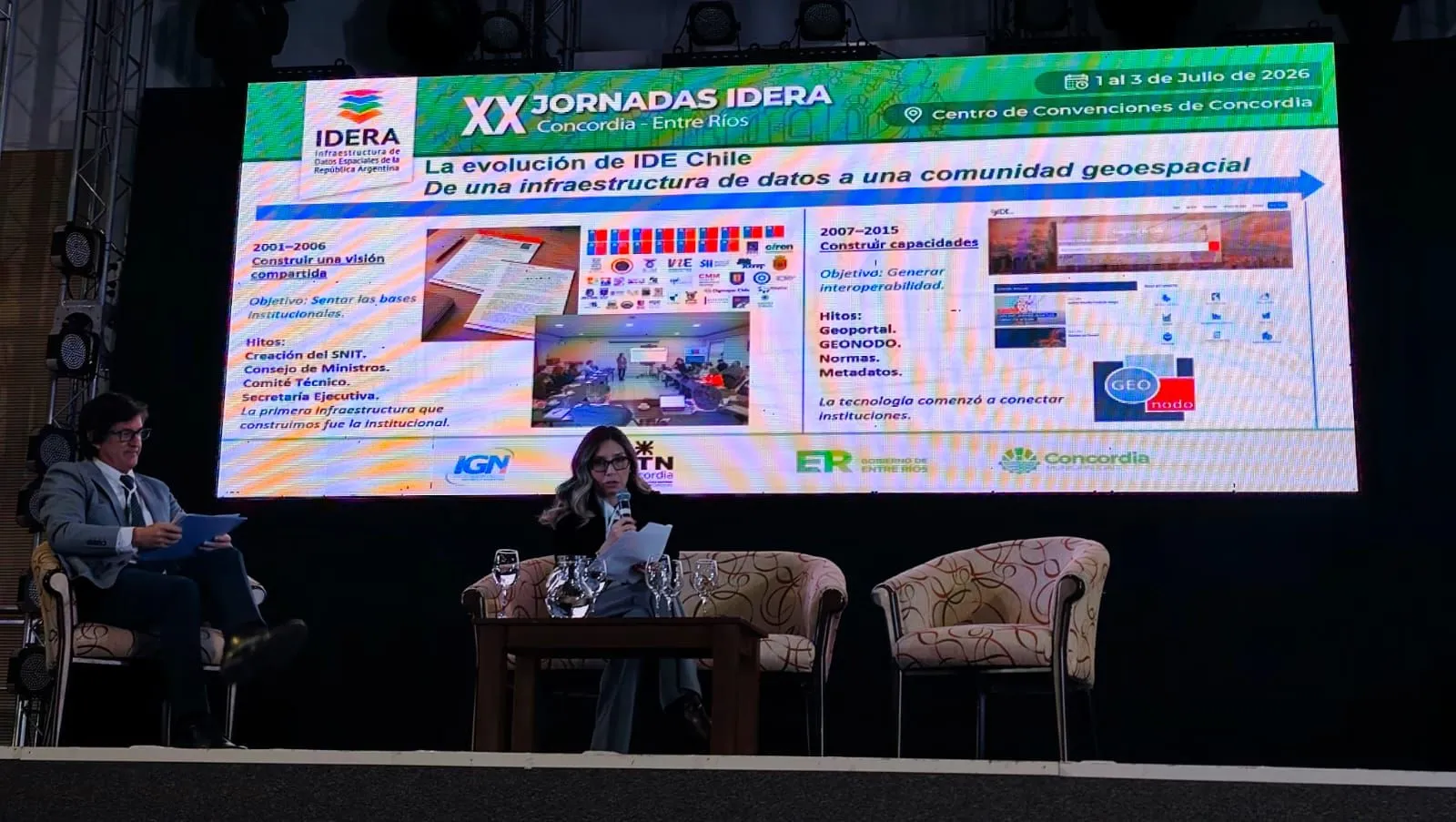Una expositora presenta «La evolución de IDE Chile: de una infraestructura de datos a una comunidad geoespacial», con la línea de tiempo de 2001 a 2015 y sus hitos: creación del SNIT, Consejo de Ministros, Geoportal, Geonodo, normas y metadatos.